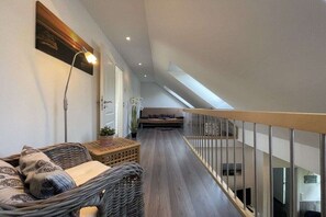 Ein modernes Interieur mit einem langen, schmalen Flur, der zu einer Treppe führt.