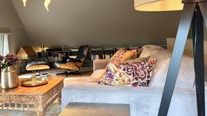 Een gezellige woonkamer met een bank, een salontafel en een boekenkast.