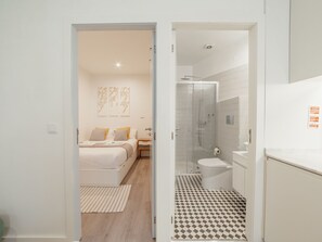 Ein modernes Badezimmer mit einer gläsernen Duschkabine, einer Toilette und einem Waschbecken.