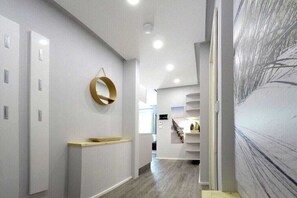 Ein modernes Interieur mit einem Flur, der zu einem Raum mit einer Treppe führt.