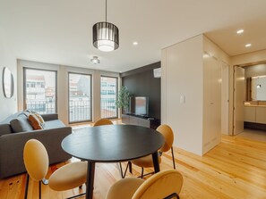 Ein stilvolles Wohnzimmer mit rundem Tisch, einer Couch und Sesseln.