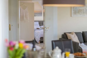 A room with a bed, a sofa, and a table with a lamp. - "Beach promenade" - directly on the beach (Ostseebad Binz)