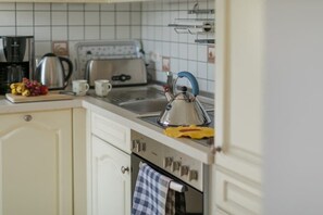 A kitchen with a kettle, a toaster, and a coffee maker on the counter. - "Beach promenade" - directly on the beach (Ostseebad Binz)