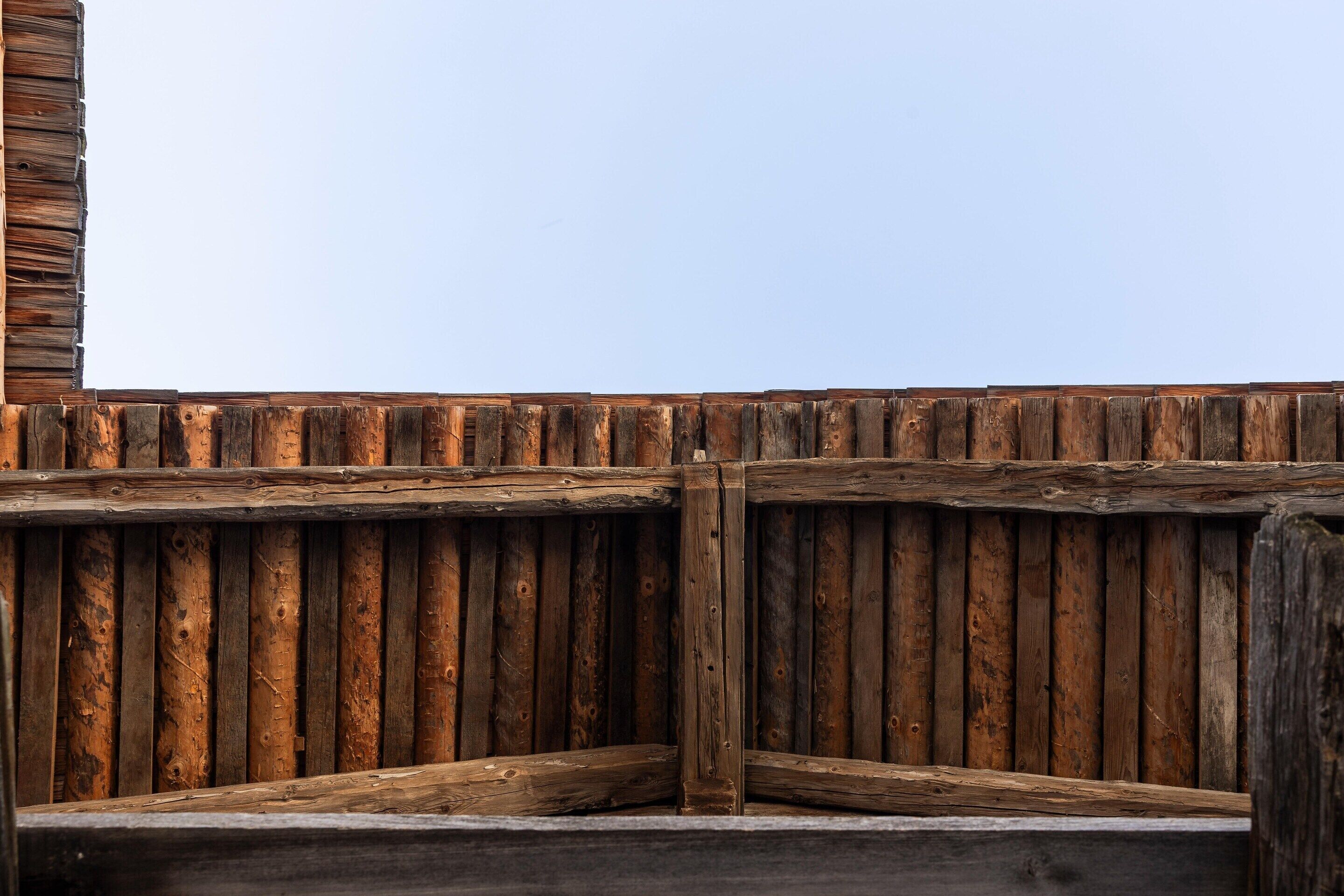 Una estructura de madera con una parte superior plana y tablones verticales.