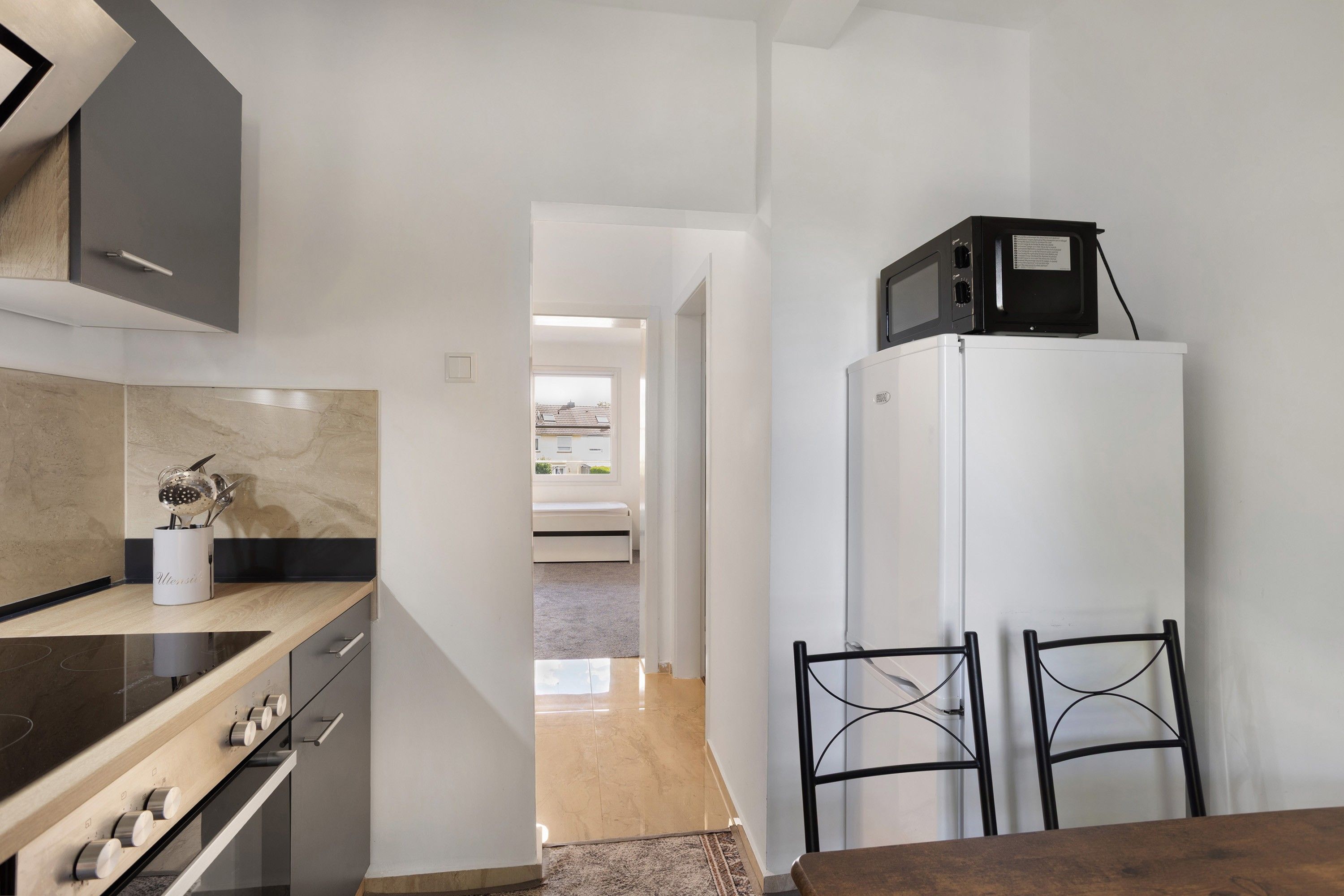 Cocina compacta con estufa, microondas y refrigerador.