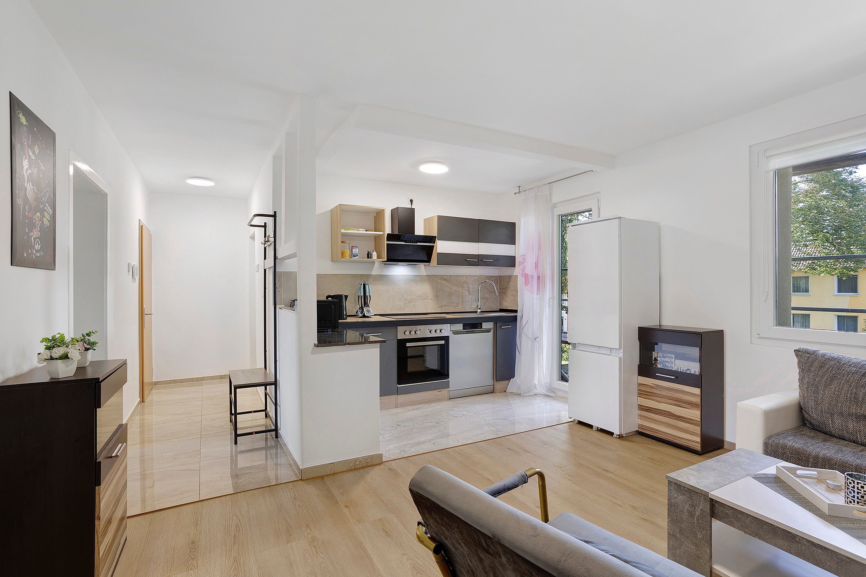 A modern apartment with a kitchen, dining area, and living room.