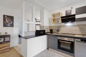A modern kitchen with a built-in oven, microwave, and a coffee maker.