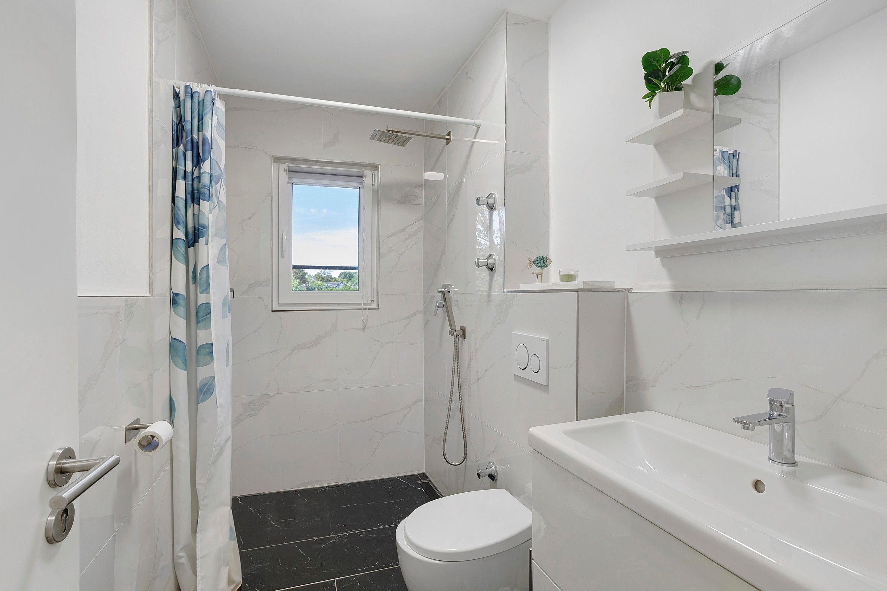 Ein modernes Badezimmer mit Dusche, Toilette und Waschbecken.