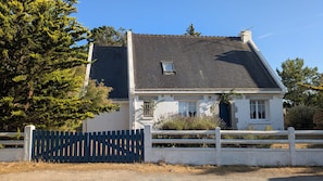 A two-story house with a dark roof, white exterior walls, and a small window. - Family Villa by the Sea (La Turballe)