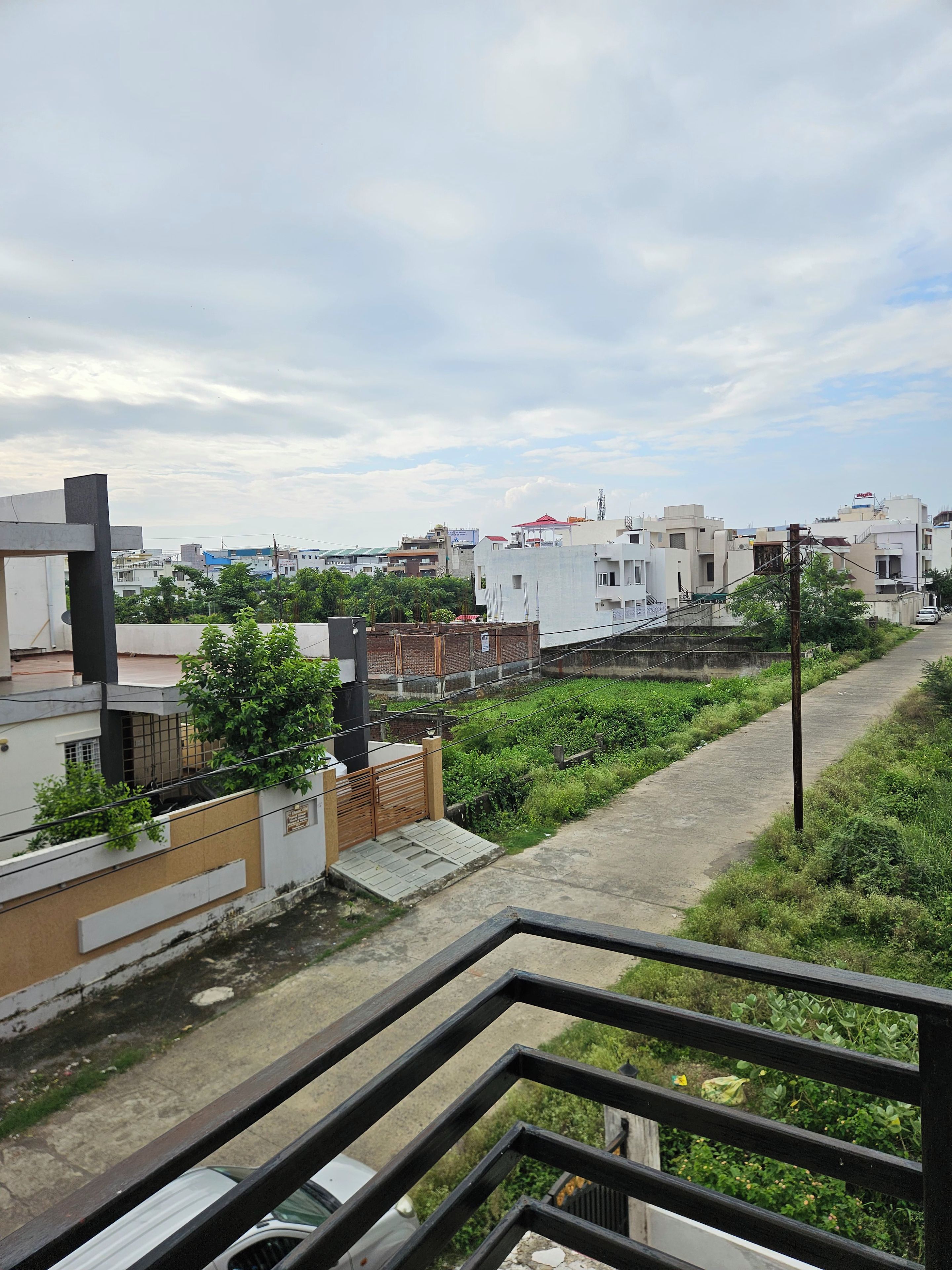 Área residencial com edifícios modernos, portão fechado e um caminho.