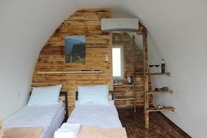 A room with two beds, wooden walls, a painting, a ladder, and a shelf with items. - Glamping Eco Valley (Shahumyan)