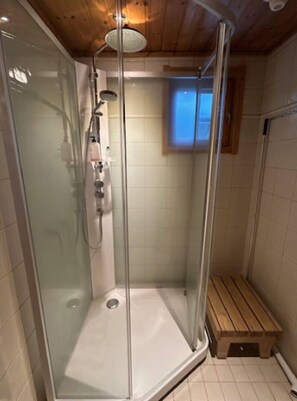 A glass-enclosed shower with a bench, wooden ceiling, and a small window. - Nietos B | Pet-Friendly Cabin with Private Sauna (Kuusamo)
