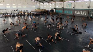 Une salle de sport spacieuse, dotée de nombreux appareils d’entraînement et d’un mur d’encouragement sur lequel on peut lire : « FORGEONS DE MEILLEURS ÊTRES HUMAINS ».