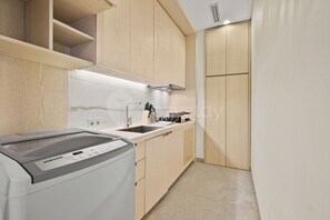 Una cocina moderna con armarios de madera, horno empotrado y campana extractora de acero inoxidable.