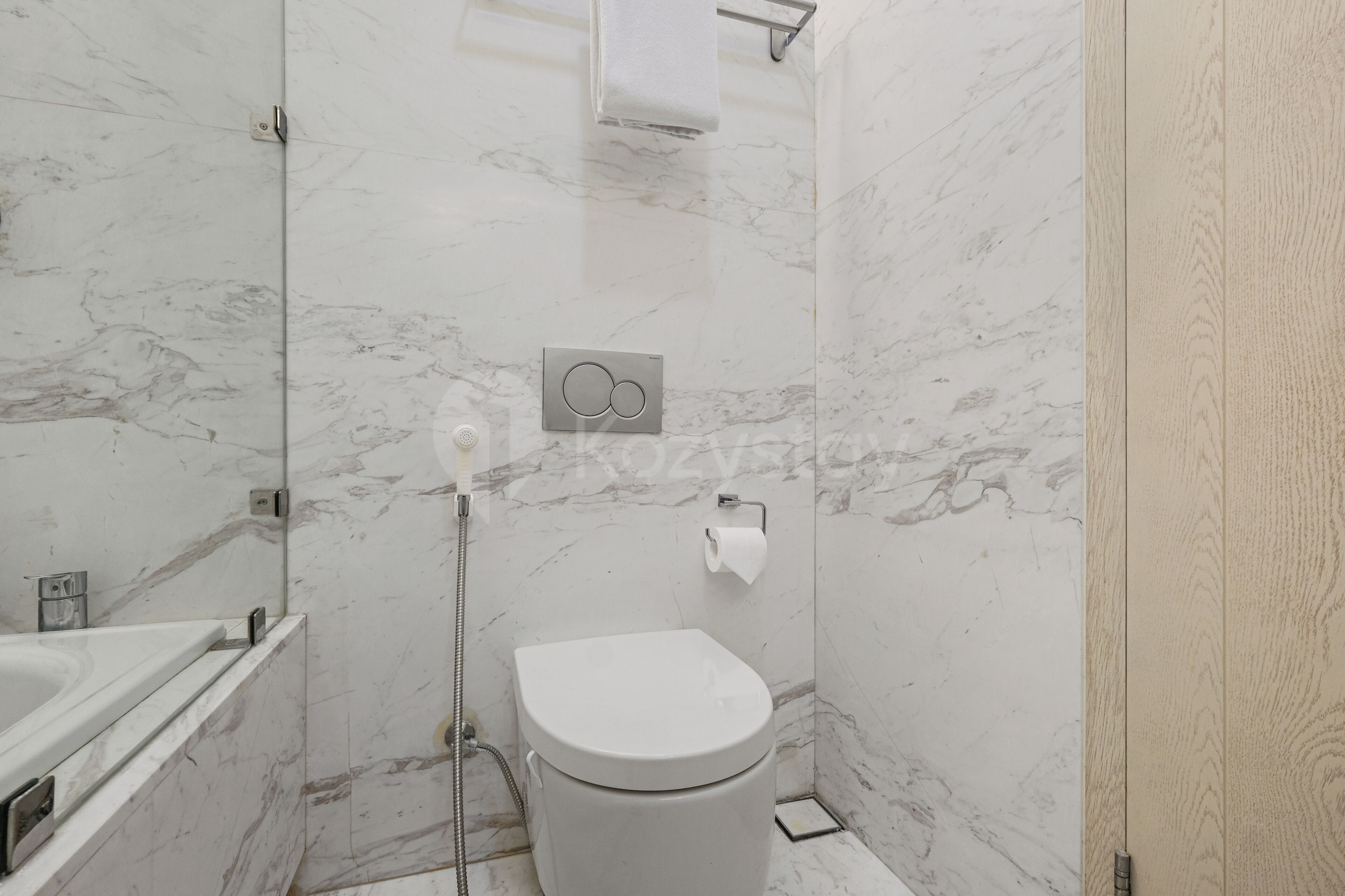Ein modernes Badezimmer mit Toilette, Dusche und Handtuchhalter.