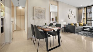 A modern living room with a dining area, a sofa set, and a large window. - Anera by Kozystay - Cilandak (South Jakarta)