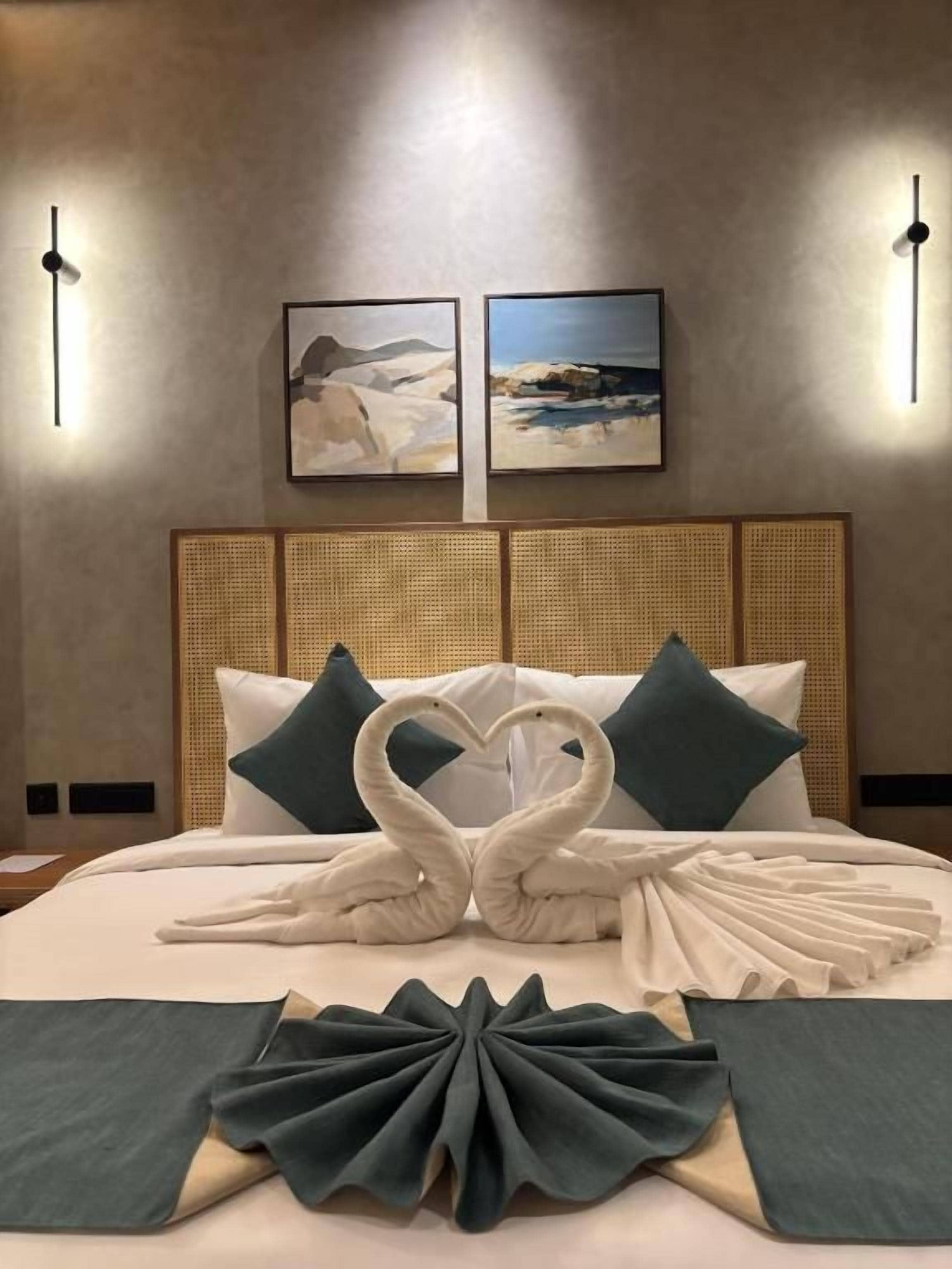 Ein Hotelzimmer mit einem Bett, zwei Wandleuchten und zwei gerahmten Bildern an der Wand.
