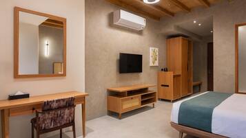 A bedroom with a bed, a desk, a chair, a TV, and a wardrobe.