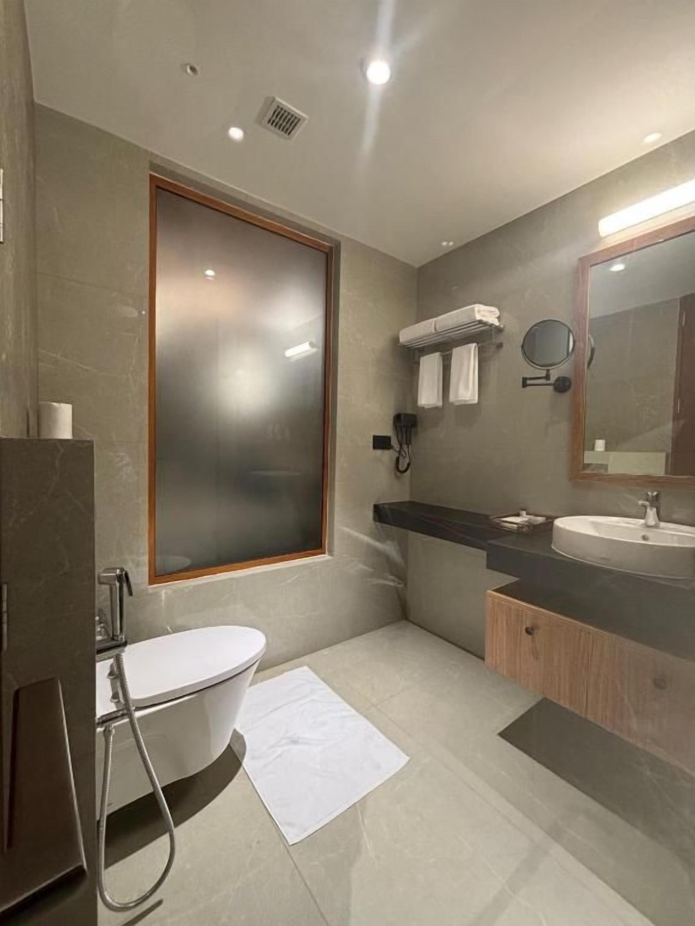 A modern bathroom with a bathtub, a sink, a mirror, and a towel rack.