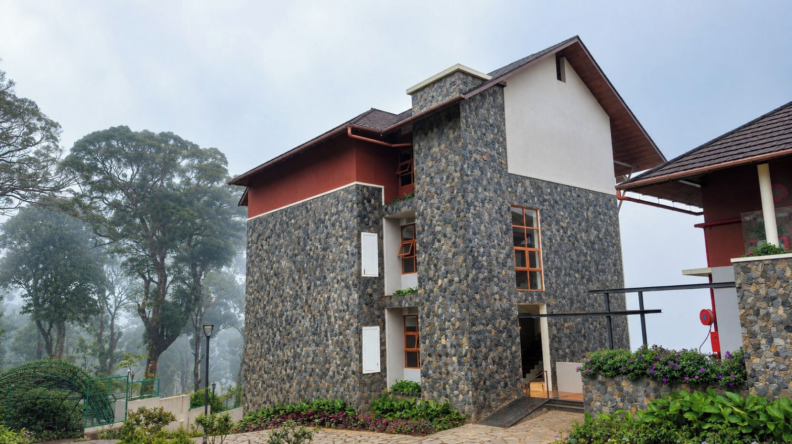 Um edifício de dois andares com fachada de pedra, telhado vermelho e escadaria que dá acesso ao andar superior.