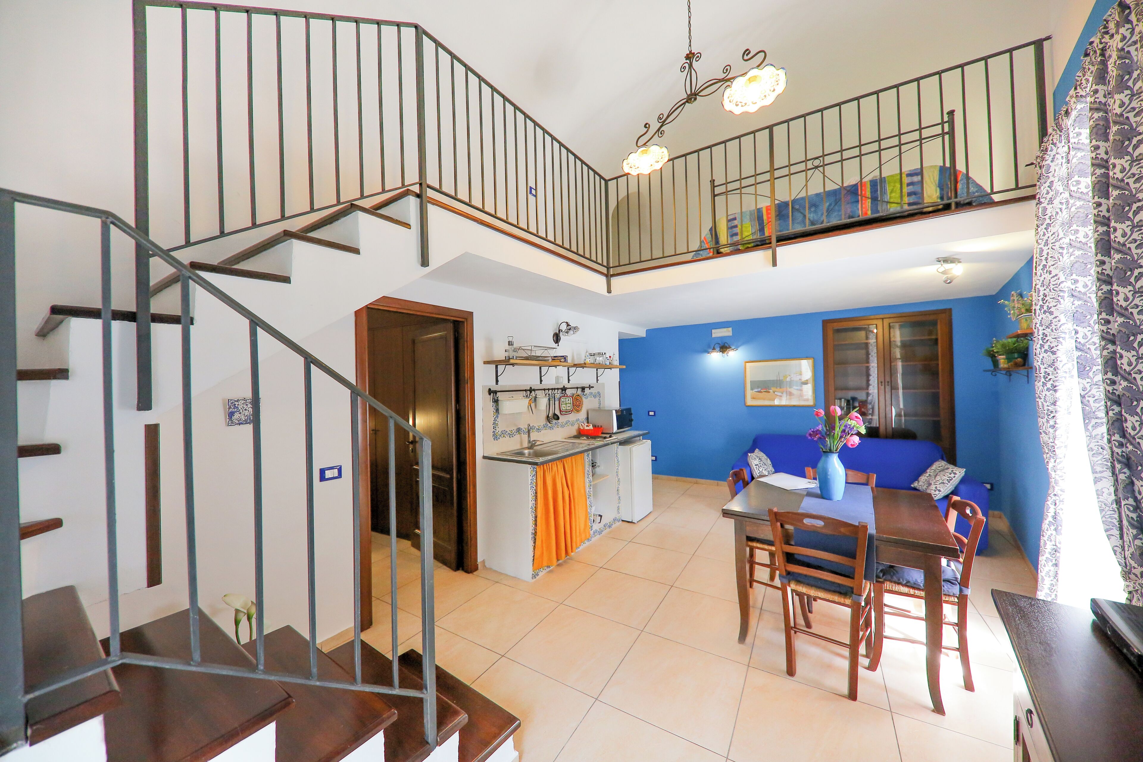 A two-story home with a staircase, a kitchen, a dining area, and a living room.