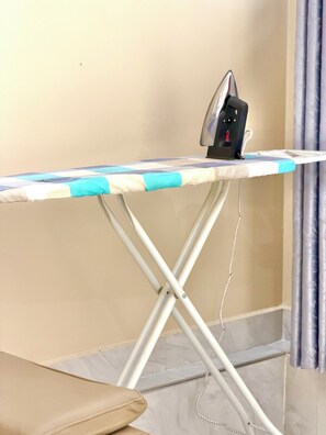 A corner of a room with an ironing board and an iron.