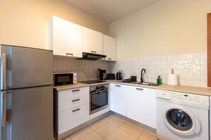 A compact kitchen with a built-in microwave, oven, and dishwasher. - Veta 31 . 1-BR Apt. & Balcony in Larnaca (Larnaca)