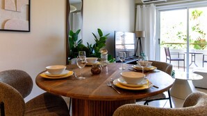 A dining area with a round wooden table set for four, surrounded by wicker chairs. - Veta 31 . 1-BR Apt. & Balcony in Larnaca (Larnaca)