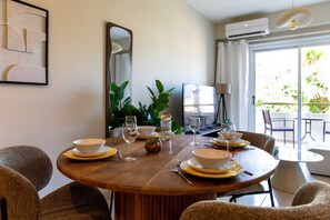 A dining area with a round wooden table set for four, surrounded by wicker chairs. - Veta 31 . 1-BR Apt. & Balcony in Larnaca (Larnaca)