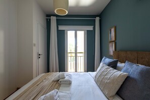 A bedroom with a bed, a window with curtains, a wall-mounted light fixture, and a door. - Veta 31 . 1-BR Apt. & Balcony in Larnaca (Larnaca)
