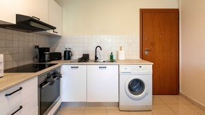 A compact kitchen with a dishwasher, oven, and a washing machine. - Veta 31 . 1-BR Apt. & Balcony in Larnaca (Larnaca)