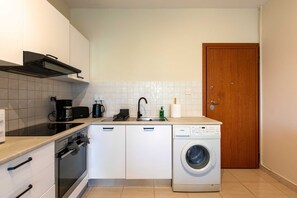 A compact kitchen with a dishwasher, oven, and a washing machine. - Veta 31 . 1-BR Apt. & Balcony in Larnaca (Larnaca)