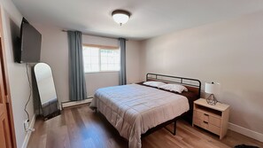 A bedroom with a bed, bedside table, lamp, and a television mounted on the wall. - Cozy Tahoe Retreat 3BR 2BA Minutes to Lake Tahoe (South Lake Tahoe)