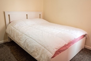 A single bed with a white headboard and a pink mattress visible. - 3-Bed Townhouse Sleeps 5 · Walk to Designer Outlet & STEAM Museum (Swindon)