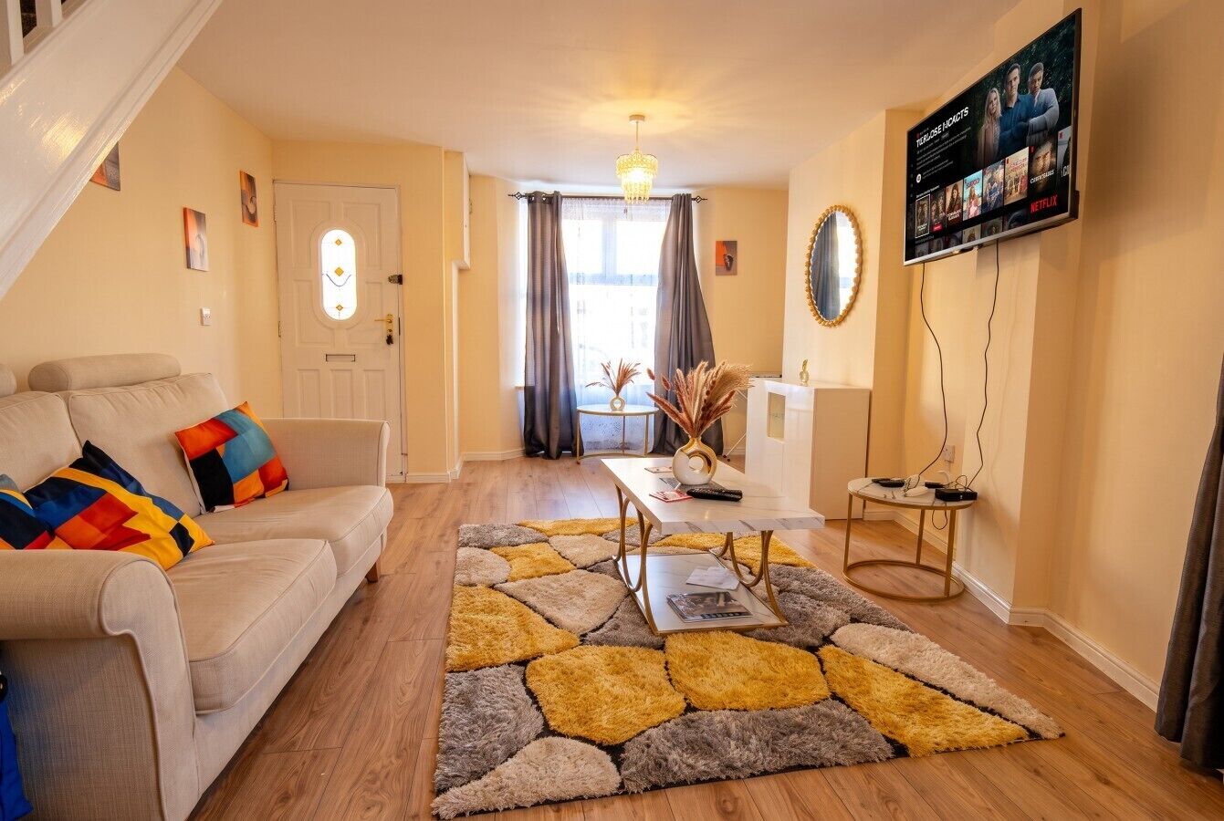 Ein Wohnzimmer mit einer Couch, einem Couchtisch und einem Fernseher, der eine Netflix-Oberfläche zeigt.
