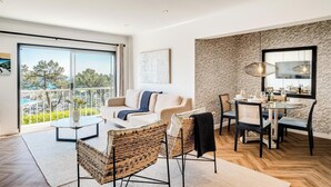 Un salon moderne comprenant un canapé, des fauteuils, une table à manger et un balcon avec vue.