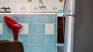 A kitchen with a tiled backsplash, a sink, and a red sink strainer. - Baobab Garden Studio with pool Watamu (Watamu)
