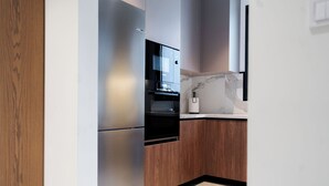 Una cocina moderna con horno empotrado, microondas y un armario de madera.