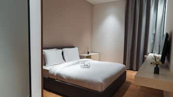 A modern hotel room with a bed, bedside table, and a flat-screen TV.
