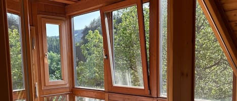 A room with large windows and a brick floor.