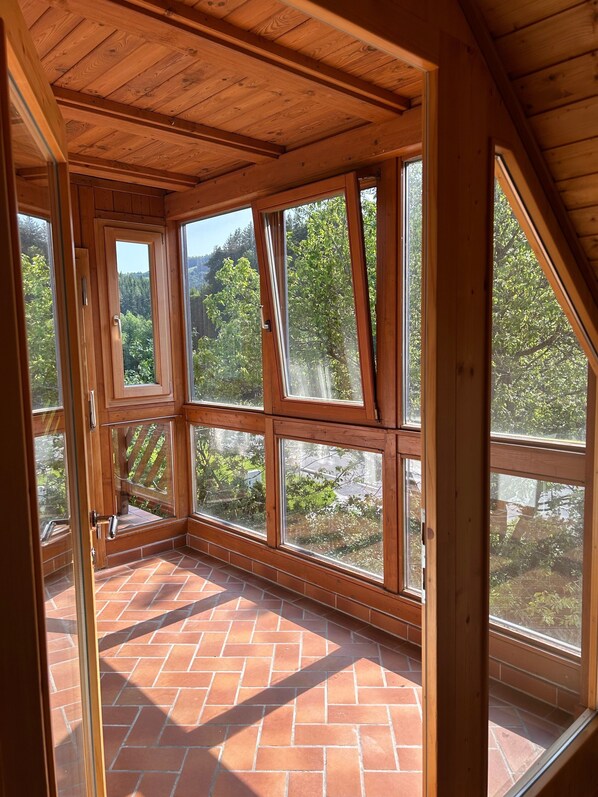 A room with large windows and a brick floor.