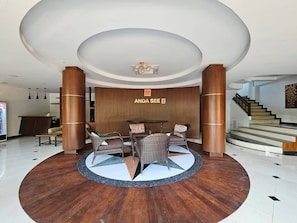 A lobby with a reception desk, seating area, and a staircase. - Anda See House (Krabi)