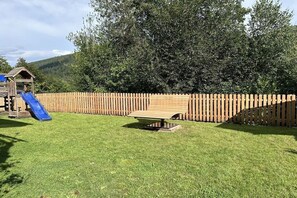 A fenced backyard with a picnic table and a slide. - Holiday apartment in Bad Wildbad with Wi-Fi (Bad Wildbad)