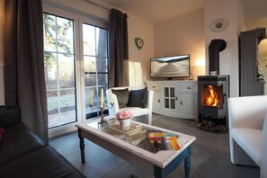 A cozy living room with a fireplace, a television, and a comfortable seating area. - My Little Zanzibar 2 (Zirchow)