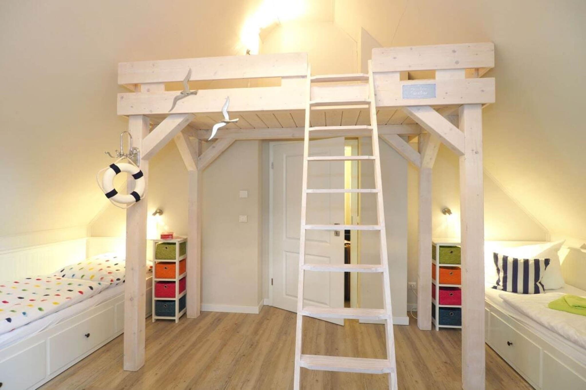 A bunk bed room with a ladder, a small shelf, and a door.