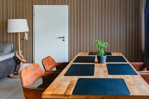 A conference room with a wooden table, black mats, and a potted plant.