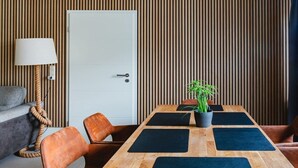 A conference room with a wooden table, black mats, and a potted plant. - Holiday apartment with 2 bedrooms (Warnemünde)