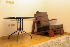 Een stoel met een hoge rugleuning en een tafel met een vlak blad en vier poten.