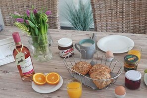 A breakfast table with bread, eggs, juice, and condiments. - Holiday apartment with 1 bedroom (Grömitz)