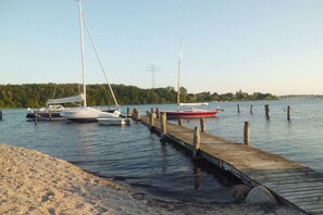 A calm lake with boats docked at a wooden pier. - Eckeberg with balcony (Hasselberg)